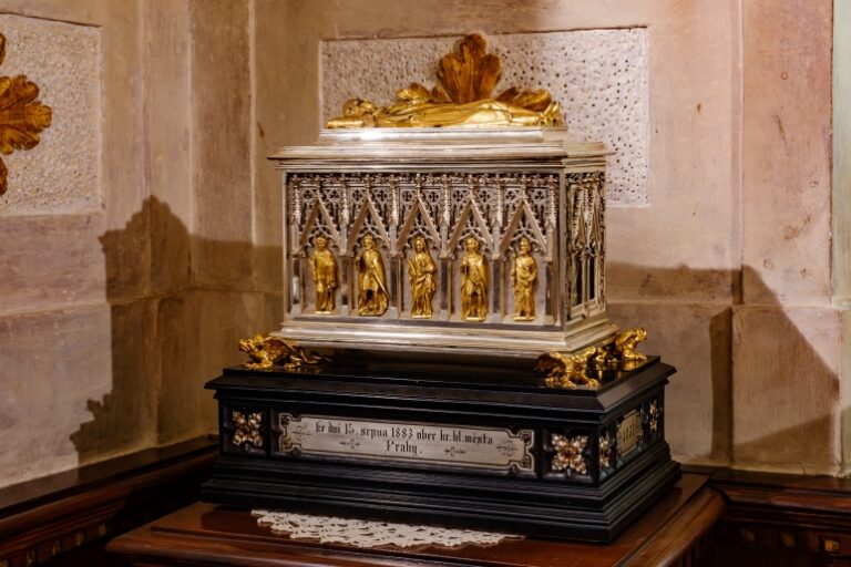 A gold and black urn on a pedestal.