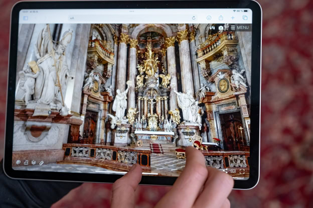 A person holding an ipad with a photo of a church.